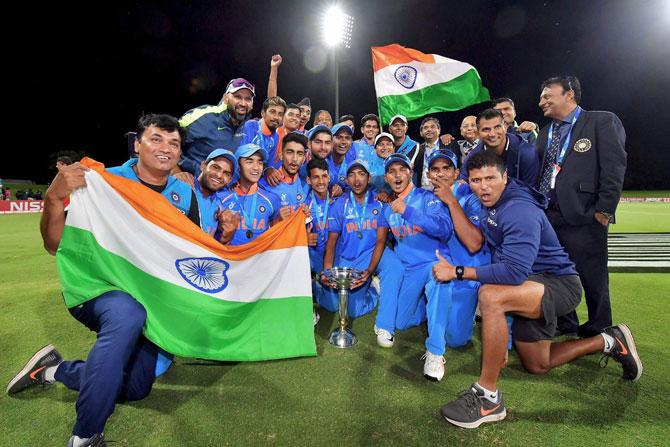 Mount Maunganui: Indian players and team coach Rahul Dravid celebrate with the trophy after winning the ICC Under-19 Cricket World Cup finals, in Mount Maunganui on Saturday. India beat Australia by eight wickets to win record fourth U-19 World Cup. (ICC via PTI Photo)