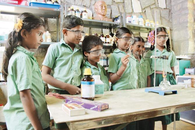 Students conduct an experiment during a training class by Agastya Foundation