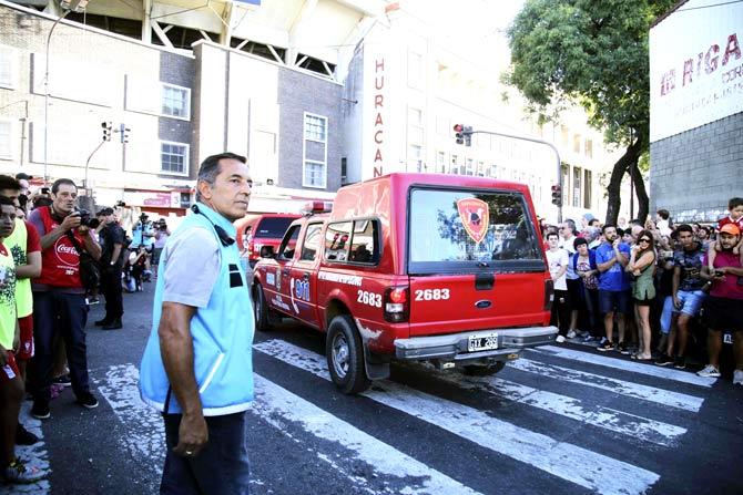 This photo released by Noticias Argentinas shows the crowds outside and the federal police explosives brigade vehicles arriving at the Tomas Duco stadium in Buenos Aires because of a bomb scare that delayed an Argentine first division football match between Huracan and River Plate. Pic/AFP