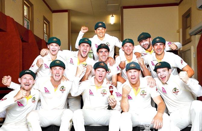 Skipper Steve Smith holds the Ashes urn as Australia celebrate in the SCG dressing room yesterday. Pic/Getty Images