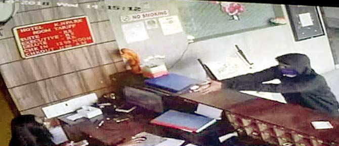 A CCTV grab shows one of the shooters firing at the receptionist