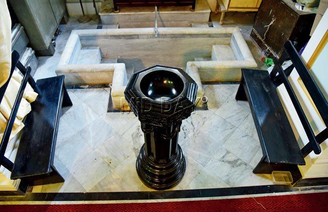 In the foreground is the wooden baptismal font for infants and in the background is the marbled baptismal pool meant for adults