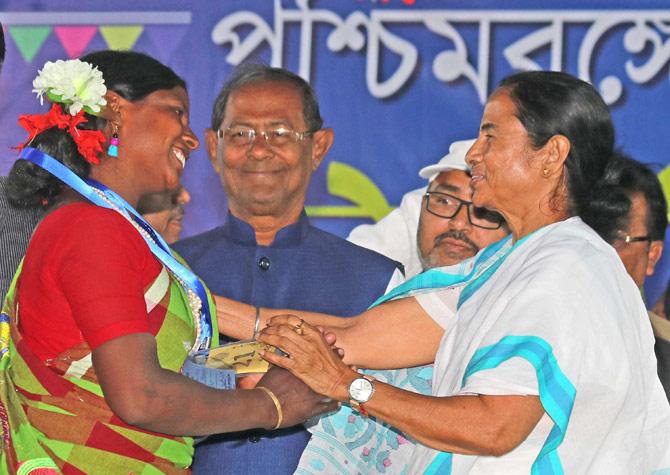 West Bengal Chief Minister Mamata Banerjee interacts with a beneficiary uring inauguration of various projects & helping aids at Ahamadpur in Birbhum district on Wednesday. Pic/PTI