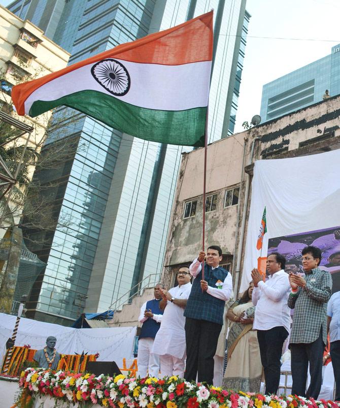 Maharashtra Chief Minister Devendra Fadnavis waves the national flag during BJP