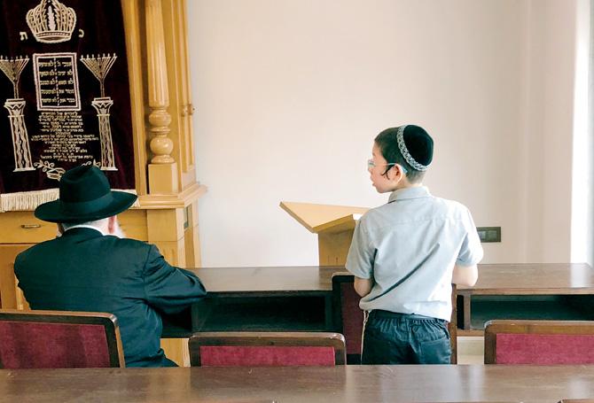Moshe Holtzberg praying with the Rabbi at Chabad House on Wednesday. Oren Rosenberg, Israeli documentary maker, who flew with the family to Mumbai from Tel Aviv on Tuesday says the 11-year-old is aware of his past and what it represents. Pic Courtesy/Oren Rosenfeld