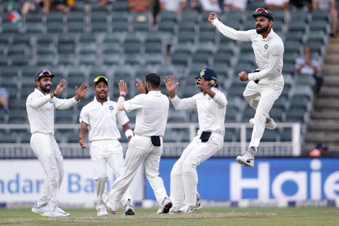 Indian Captain Virat Kohli (R) and bowler Mohammed Shami (3R) celebrate the dismissal of South African batsman Aiden Markram (not in picture) during the third day of the third test match between South Africa and India at Wanderers cricket ground on January 26, 2018 in Johannesburg. / AFP 
