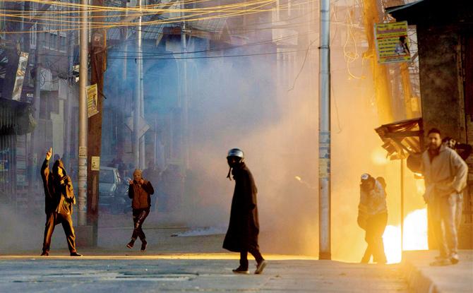 A teargas shell explodes near protesters in Srinagar clashing with security forces against the alleged killing of the two youth in Army firing. Pic/PTI