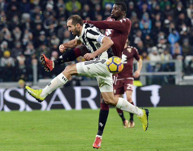 Juventus Giorgio Chiellini, left, and Torinos MBaye Niang vie for the ball during an Italian Cup quarter-final soccer match between Juventus and Torino at the Allianz Stadium in Turin, Italy, Wednesday, Jan. 3, 2018. Pic/AP/PTI