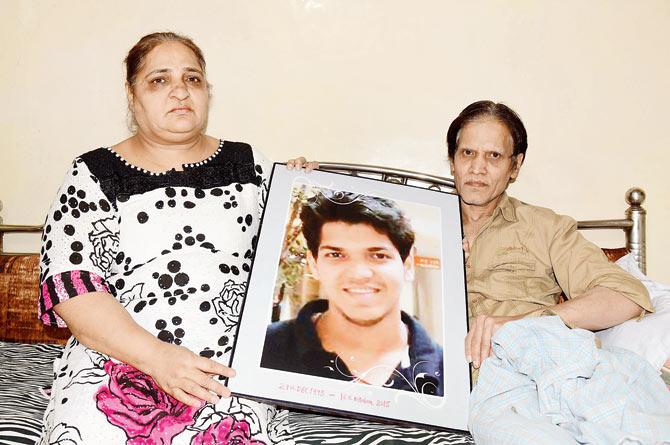 Rekha and her bedridden husband Pradeep hold up a picture of their son Akash in  their Sion Koliwada home. Pic/Suresh KK