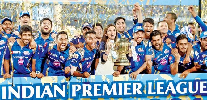 Mumbai Indians players and owner Nita Ambani pose with the Indian Premier League-10 trophy in Hyderabad last year. Pic/PTI
