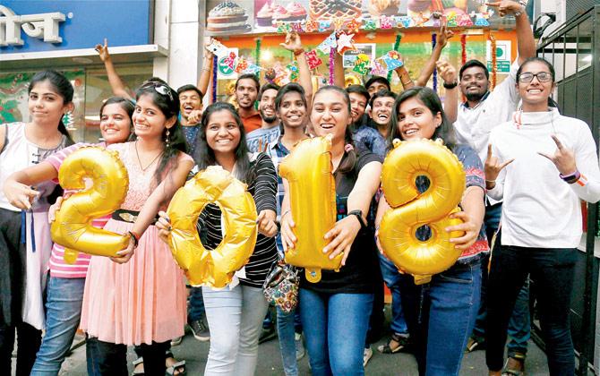 A group of youngsters wishes passers-by a happy new year in Thane on Saturday. Pic/PTI