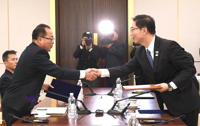 South Korean Unification Ministry on January 17, 2018 shows South Korean chief delegate Chun Hae-Sung (R) shaking hands with North Korean chief delegate Jon Jong-Su (L) as they exchange joint statements during their working-level talks at the South side of the border truce village of Panmunjom in the Demilitarized zone dividing the two Koreas. Pic/AFP