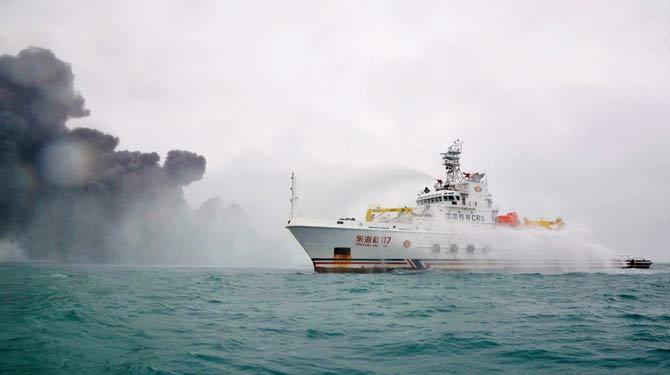 Chinese firefighting vessel spraying water on the burning oil tanker anchi. Pic/AFP