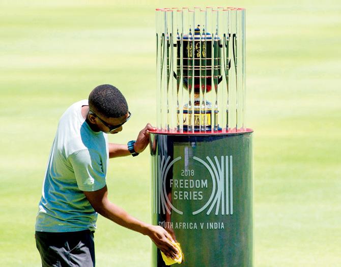 A groundsman cleans the casing of the 2018 Freedom Series trophy for which SA and India will play three Tests, beginning today in Cape Town. pic/AFP