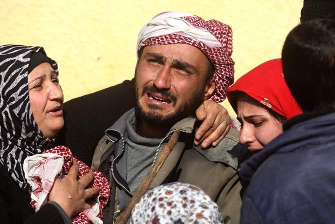 Relatives of a Kurdish herder mourn outside the hospital in Afrin. Pic/AFP