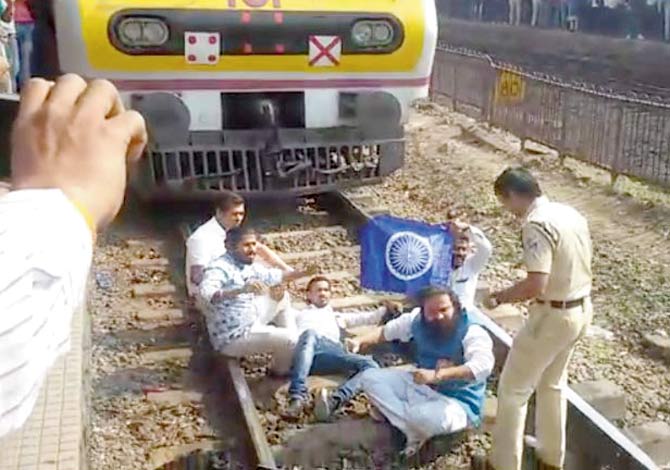 A group of five protesters from Dalit Youth Panther jumped on the railway tracks in Thane on Thursday afternoon, stopping a CSMT-bound train and demanding arrest of Bhide Guruji and Milind Ekbote. All the five were detained by the RPF. Railway officials said no force was used to remove them from the spot
