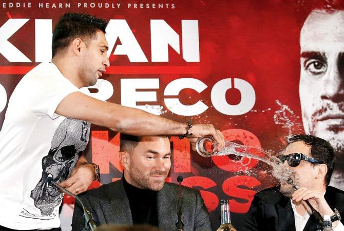 Amir Khan throws a glass of water over his next opponent Phil Lo Greco during a media interaction in Liverpool yesterday. Pic/ Getty Images
