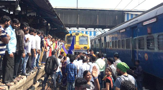 RPI activists stop a local train at Thane railway station during a day-long bandh call over Bhima Koregaon violence, in Mumbai on Wednesday. Pic/PTI