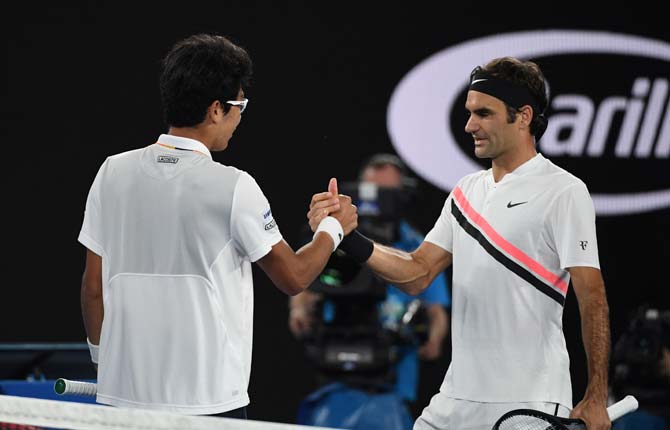 Chung Hyeon shakes hands with Roger Federer after retiring from Australian Open men