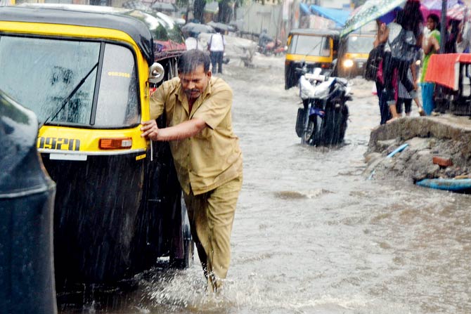 A driver pushes his auto on a waterlogged street on Tuesday. Pic/Datta Kumbhar