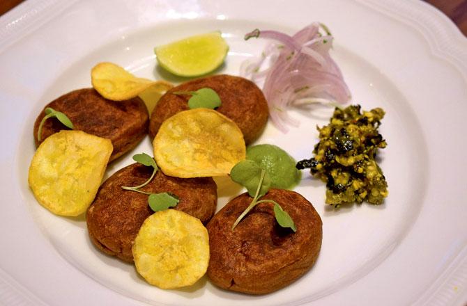 Kanchkolar shammi kebabs: The sweetness of green banana kebabs is cut with a spicy green chutney and a roasted chilli and mustard relish. Served with coriander chutney and banana chips, this is a perfect monsoon indulgence.  
