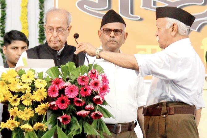 Former president Pranab Mukherjee speaks as RSS chief Mohan Bhagwat adjusts the mike at an (RSS) event in Nagpur on June 7, 2018. Pic/PTI