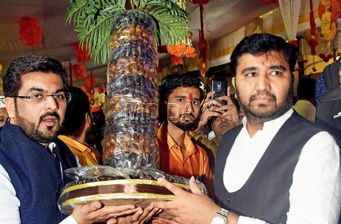 Party members arrive bearing an edible arrangement of dates held up by a plastic sheet. Pics/Sameer Markande