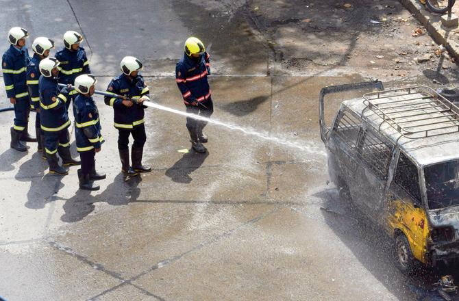 Fire Brigade personnel douse the blaze that gutted the van near Parel Bus Depot when the kids were being dropped back home. Pics/Ashish Raje