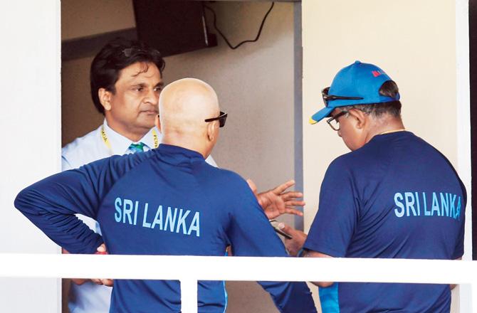 ICC match referee Javagal Srinath talks to Sri Lankan coach Chandika Hathurusingha (centre) and team manager Asanka Gurusinha (right) prior to third day