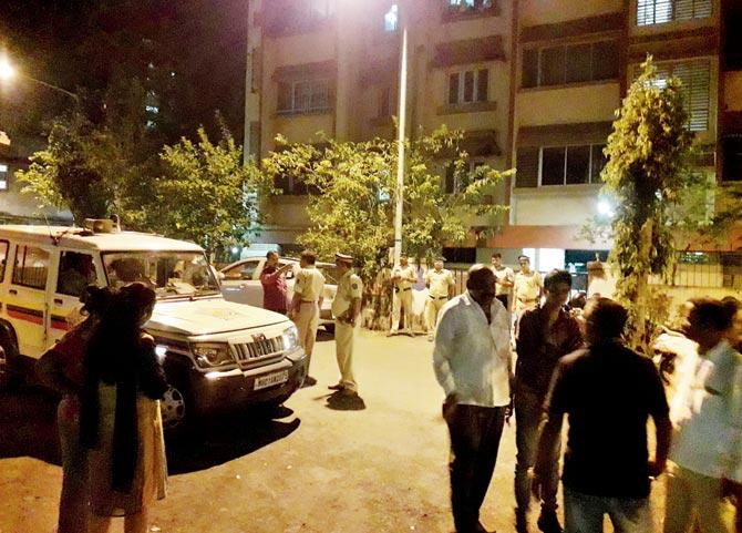 Policemen, friends and neighbours outside Megha Apartments