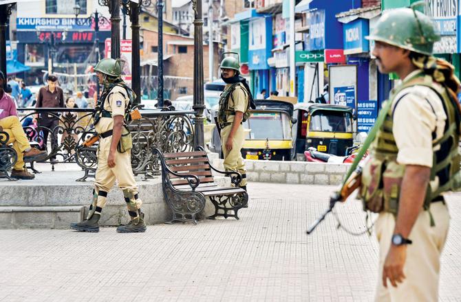 Security personnel stand guard at Lal Chowk area in Srinagar, on Tuesday. Pics/PTI