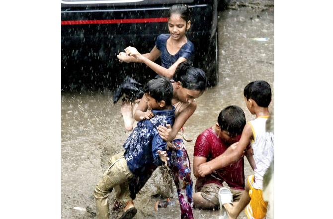 Children play about in the rain at Sion. Pic/Pradeep Dhivar