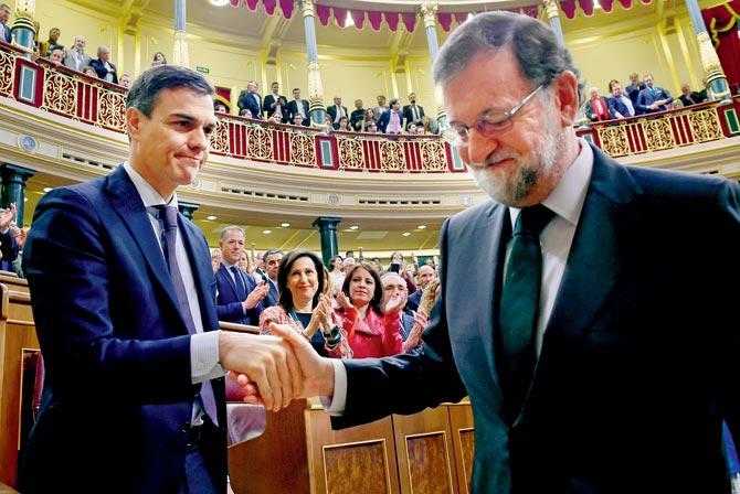 Pedro Sanchez (left) shakes hands with out-going PM Mariano Rajoy