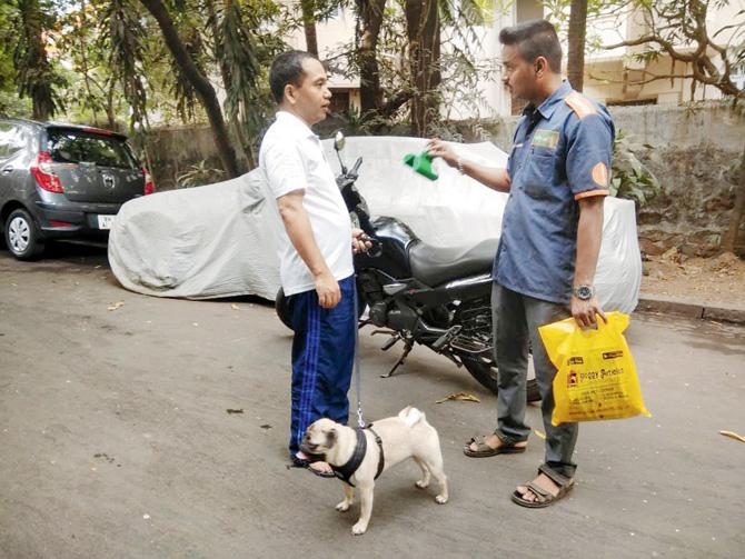 BMC staffer shows a citizen how to use a poop scoop