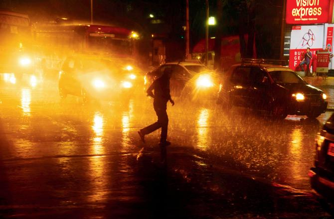 A man tries to escape the heavy rains in Dadar on Saturday