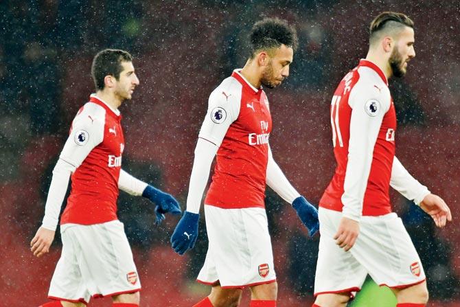 Arsenals Henrikh Mkhitaryan (left), Pierre-Emerick Aubameyang and Sead Kolasinac (right) leave the pitch after their 0-3 loss to Man City