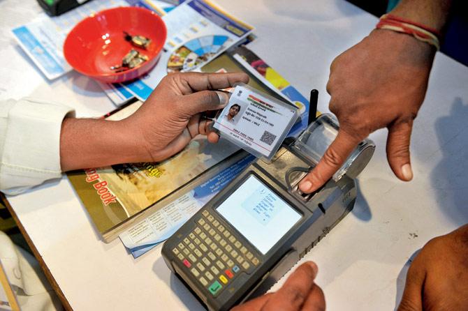 A man gives a thumb impression to withdraw money from his bank account with his Aadhaar card during a Digi Dhan Mela, held to promote digital payment, in Hyderabad. File Pic/AFP