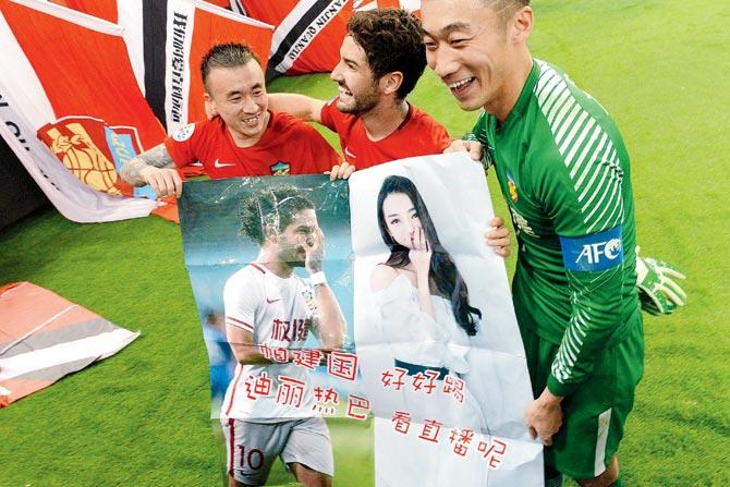  Alexandre Pato of Tianjin Quanjian (centre) and teammates hold posters of him and Chinese actor Dilraba Dilmurat after an AFC match in Shanghai.   PIC/AFP