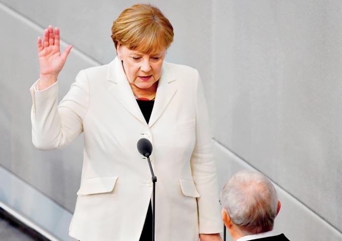 German Chancellor Angela Merkel takes the oath of office in front of Parliament President Wolfgang Schaeuble. Pic/AFP
