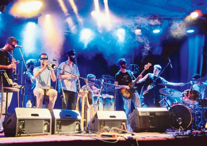 The Blind Orchestra plays live, with a conductor on the extreme right
