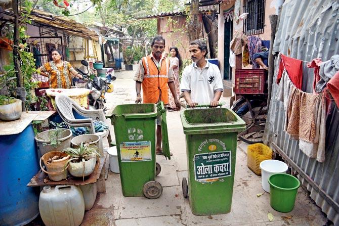 Safai mitras at the Bhadranagar slums in Kandivli, who collect the wet and dry garbage in separate wheelie bins. Pics/Nimesh Dave
