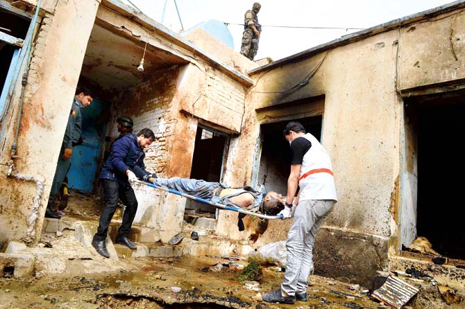 Afghan personnel carry the body of man on a stretcher. Pic/AFP