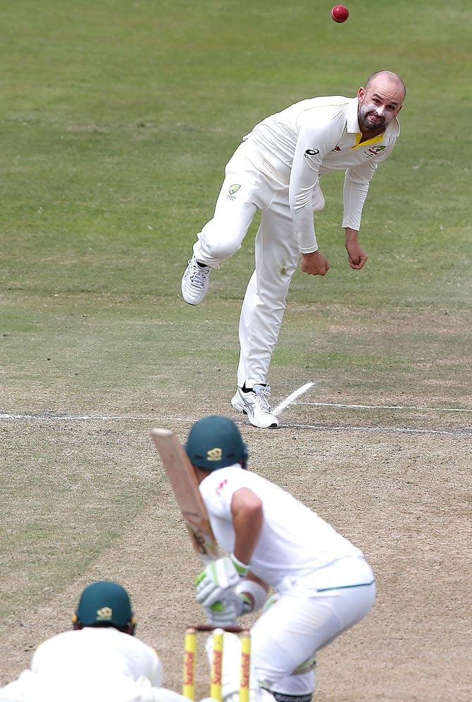 Australian bowler Nathan Lyon (TOP) delivers the ball to South African batsman Dean Elgar during the fourth day of the first Test cricket match between South Africa and Australia at The Kingsmead Stadium in Durban on March 4, 2018. Pic/AFP
