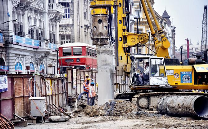 A double-decker BEST bus passes by a site where work is on for Metro 3. Pics/Pradeep Dhivar