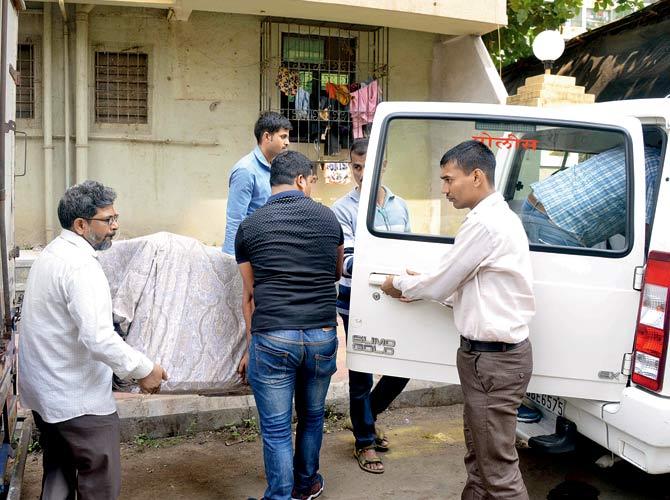 Cops seize a fridge from flat 401 of Mukund Plaza in Bhayander East, where the main accused stayed on rent. Pics/Hanif Patel