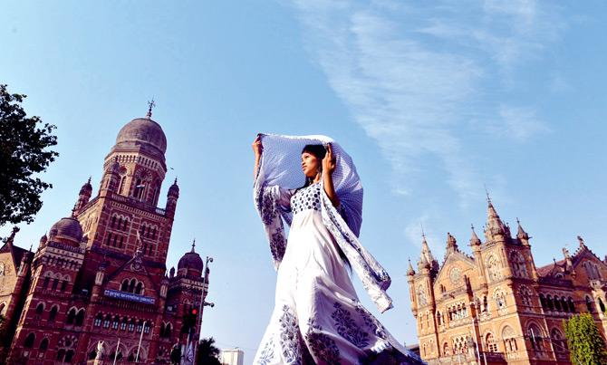 A woman raises her dupatta for some much-needed shade under the scorching sun on Sunday. Pic/Bipin Kokate