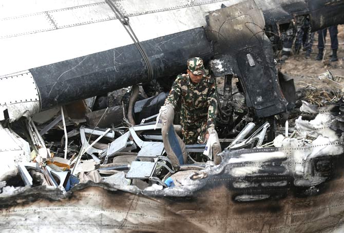 A Nepali rescue worker looks through wreckage of an airplane that crashed near the international airport in Kathmandu.Pic/AFP