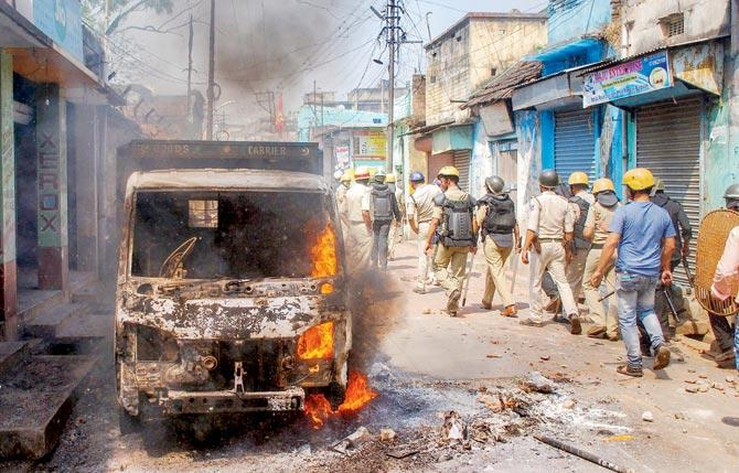 Police personnel patrol after clashes over Ram Navami rallies at Raniganj in Burdwan district on Monday. Pic/PTI