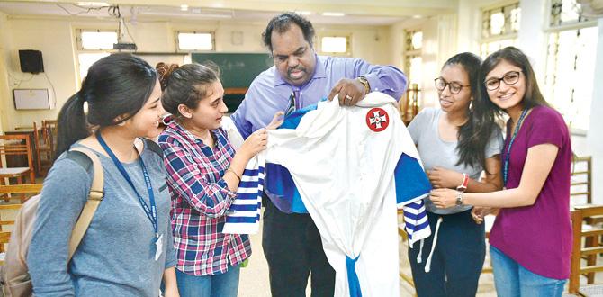 Daryl Davis shows students a Ku Klux Klan robe, worn by the white supremacist cult. Pic/Bipin Kokate