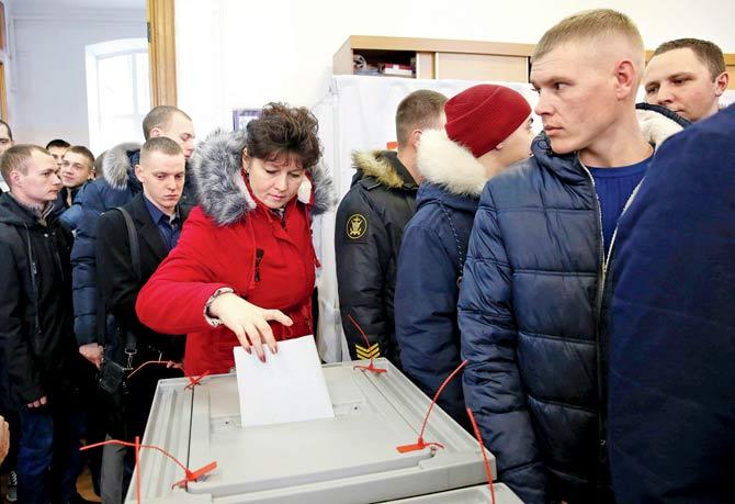 While a voter puts hers at a polling station in the port city of Vladivostok, on Sunday. Pics/AP